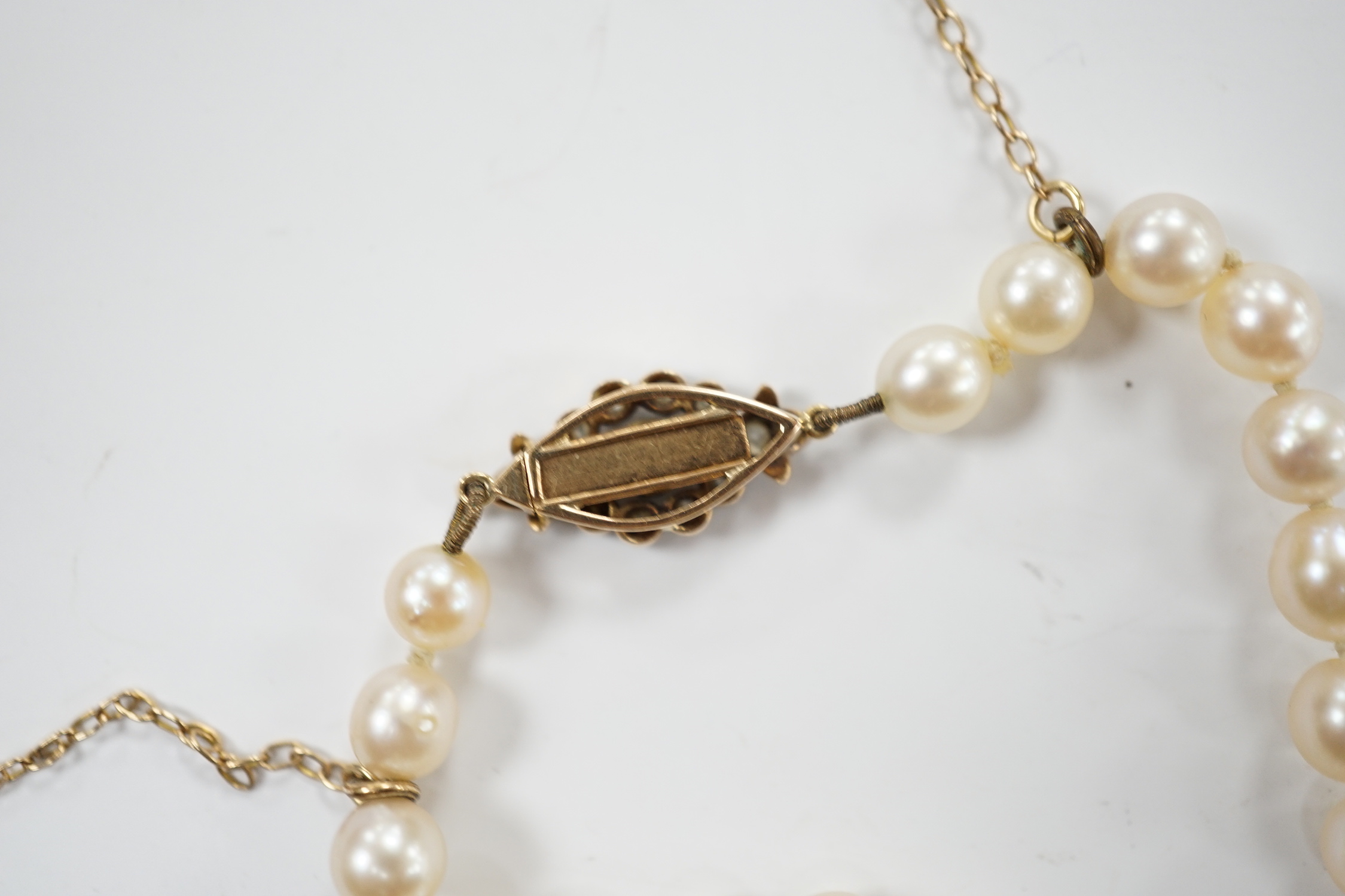 A single strand graduated cultured pearl necklace with millegrain set diamond cluster and yellow metal clasp, 40cm.